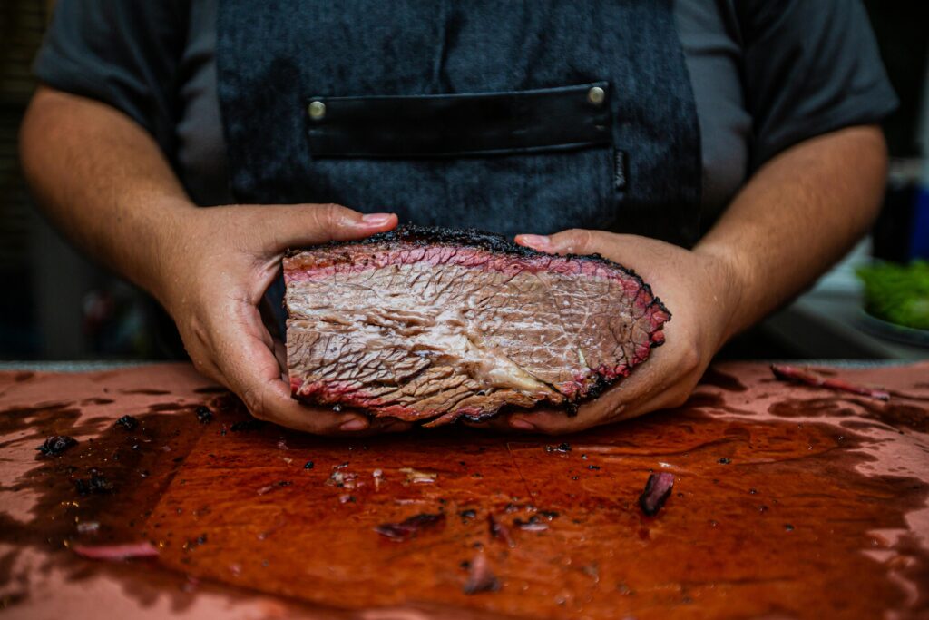 Man holding a smoked brisket