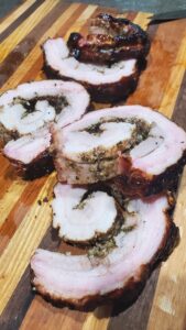 smoked and sliced porchetta on a cutting board